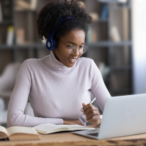 Woman wearing headphones sitting at a laptop