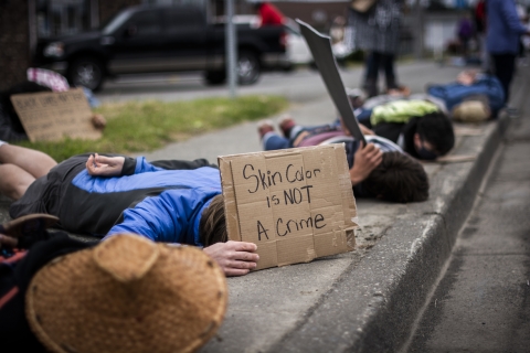 People laying on a sidewalk in protest holding signs that read "I can't breathe."