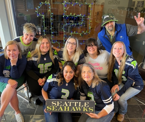 Group of people in Seattle Seahawks gear posing for a photo