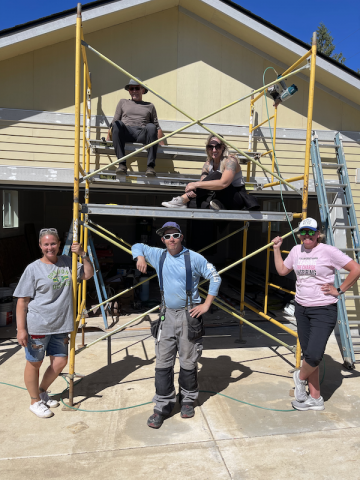 Five people standing in front of a house under construction