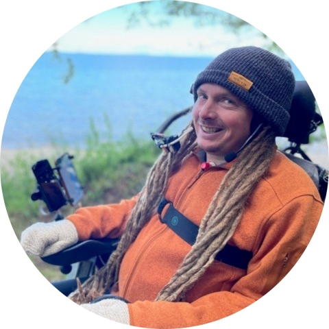 Smiling man in a wheelchair near a body of water