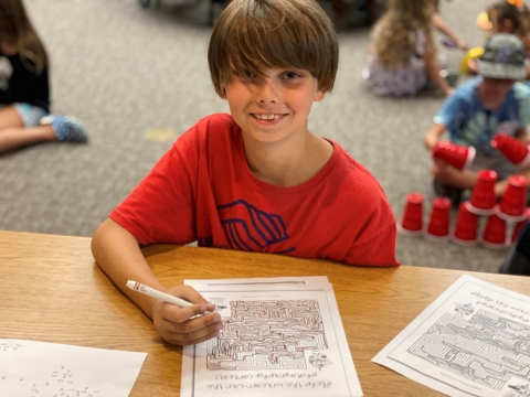 Boy smiling while working on homework