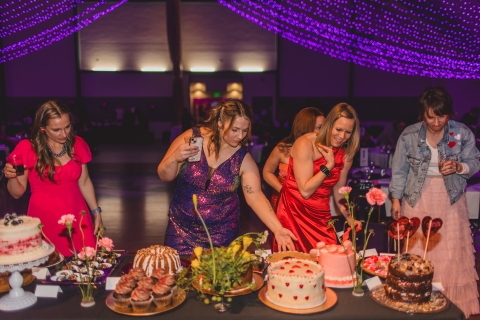 women at table of desserts