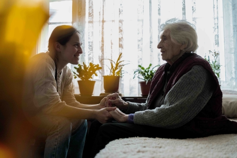 An old woman and a younger woman holding hands