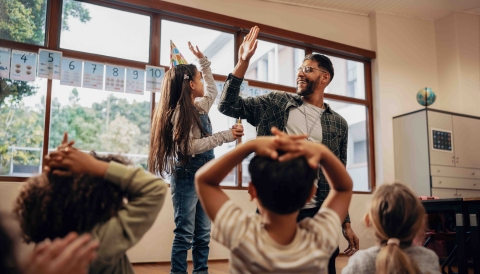 child and teacher giving high-five