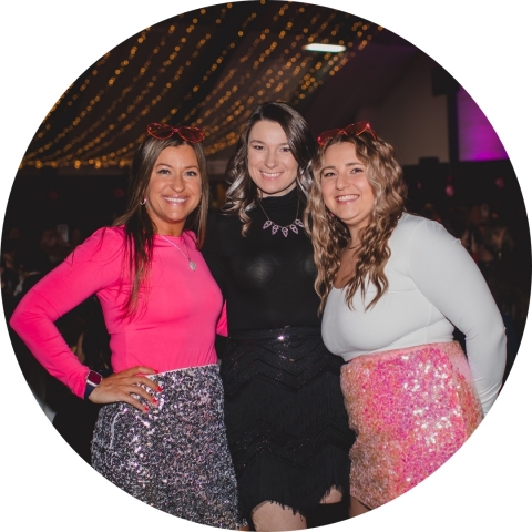 Three smiling women at a fancy event